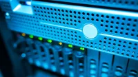Focused view of a modern data server rack with blinking lights in a blue-lit environment.
