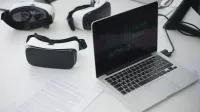 Espacio de trabajo moderno con auriculares portátiles y VR, ideal para temas tecnológicos.