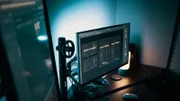 A stylish modern workspace with dual monitors displaying design software in a dimly lit room.