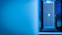 Close-up of a modern server unit in a blue-lit data center environment.