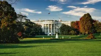 A view of the White House surrounded by autumn foliage and a central fountain in Washington, DC.