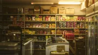 Estante repleto de diversos bocadillos y comestibles asiáticos en un acogedor entorno de tienda.