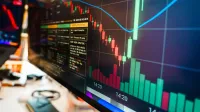 Close-up of a financial monitor displaying real-time cryptocurrency data and charts in a modern office.