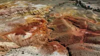 A stunning aerial view of colorful geological formations resembling a Martian landscape.