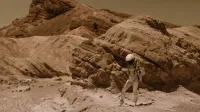 An astronaut in a space suit explores a barren desert landscape, resembling an alien planet.