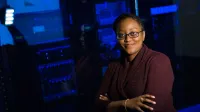 Confident woman in data center, showcasing tech expertise.