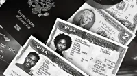 A black and white composition of a US passport, visas, and currency, showcasing travel essentials.