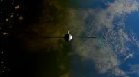A satellite orbiting Earth showcasing contrasts between ocean and land from space.