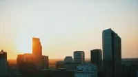 Silhouette of modern skyscrapers against a vibrant sunset, showcasing urban architecture.