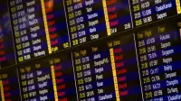 Close-up de la junta de información de vuelo digital que muestra las llegadas y salidas en un aeropuerto.