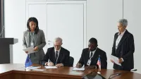 Business leaders signing a significant agreement in a conference room setting.