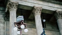 An elegant view of classic architectural columns with an antique street lamp, ideal for urban landscapes.