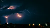 Striking lightning illuminates the dark sky over Belo Horizonte at night, capturing the energy of an urban thunderstorm.