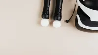 Top view of gaming controllers and VR headset on neutral background.