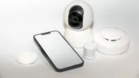 Collection of smart home security gadgets with a smartphone display.