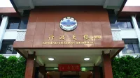 Vista frontal de la entrada del edificio de administración de la Universidad Ming Chuan, que muestra su diseño arquitectónico.
