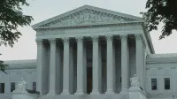 Front view of the iconic Supreme Court building with classical columns and majestic architecture.