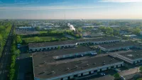 Expansive aerial view of an industrial area showcasing buildings, roads, and green spaces.