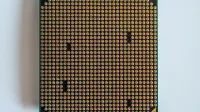Detailed view of a computer processor, showcasing its pins, against a clean white backdrop.