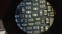 Detailed image of microchip components viewed through a microscope lens.