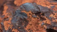 Detailed texture of iron ore rock in Minas Gerais, Brazil, showcasing earthy tones and mineral structures.