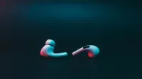 Close-up of wireless earphones on a moody dark backdrop. Ideal for tech themes.