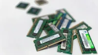Assorted RAM modules scattered on a white surface, showcasing technology components.
