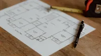 Architecture scheme of floor on paper placed on wooden surface near pen and ruler in room during renovation work in building