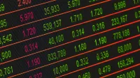 Close-up of a digital stock market data display showing colorful financial numbers and trends.