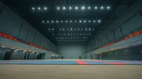 Spacious indoor sports hall with bright ceiling lights and empty flooring in Surat, India.