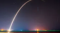 A breathtaking shot of a rocket launch, creating a vivid trail under a starry night sky.