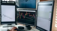 A multi-monitor stock trading setup showcasing charts and data analysis in a home office setting.