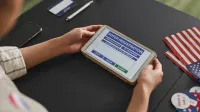 A person using a tablet for voter registration, highlighting digital voting processes.