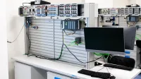 A contemporary office showcasing a server rack and computer workspace, ideal for tech and business settings.