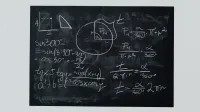 Detailed view of mathematical equations and diagrams on a blackboard.