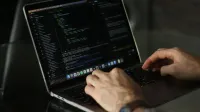 Primer plano de manos codificando en una computadora portátil, centrándose en la productividad de programación.