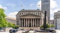 View of the historic New York County Courthouse with clear skies and cityscape.