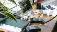 A bright modern office desk setup with electronic devices and plants, ideal for productivity.