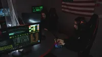 Cybersecurity professionals working on computer systems, focusing on data protection in a dimly lit room.