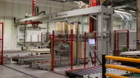 Industrial machinery with robotic arm in a modern manufacturing facility.