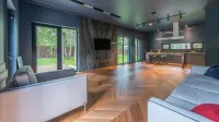 Contemporary living room featuring wooden floors, large windows, and stylish decor.