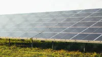 Expansive solar panel array harnessing clean energy in a sunny outdoor field scene.