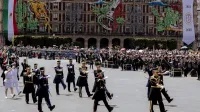 Colorful military parade in Zócalo Square, Mexico City, celebrating national pride.