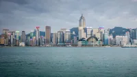 Spectacular daytime view of Hong Kong skyline with harbor in foreground.