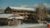 Winter scene with snow-covered rustic buildings and mountains in Colorado.