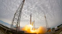 Wide angle of space station during liftoff of rocket after countdown against cloudy sky