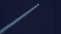 Un cohete asciende hacia el cielo, dejando un rastro de humo contra el cielo azul claro.
