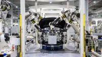 High-tech robots assembling a car in a modern factory setting, showcasing automation.