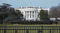 La icónica Casa Blanca con bandera americana y césped verde durante la temporada de invierno en Washington, DC.