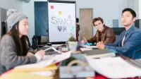 A group of young professionals brainstorming ideas in a startup office setting.